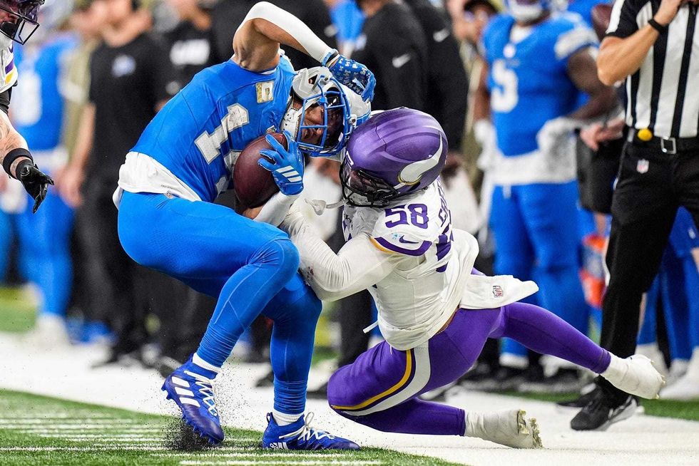 Detroit Lions wide receiver Amon-Ra St. Brown (14) makes a catch against Minnesota Vikings linebacker Jonathan Greenard (58) during the second half at Ford Field in Detroit on Sunday, November 2, 2025.