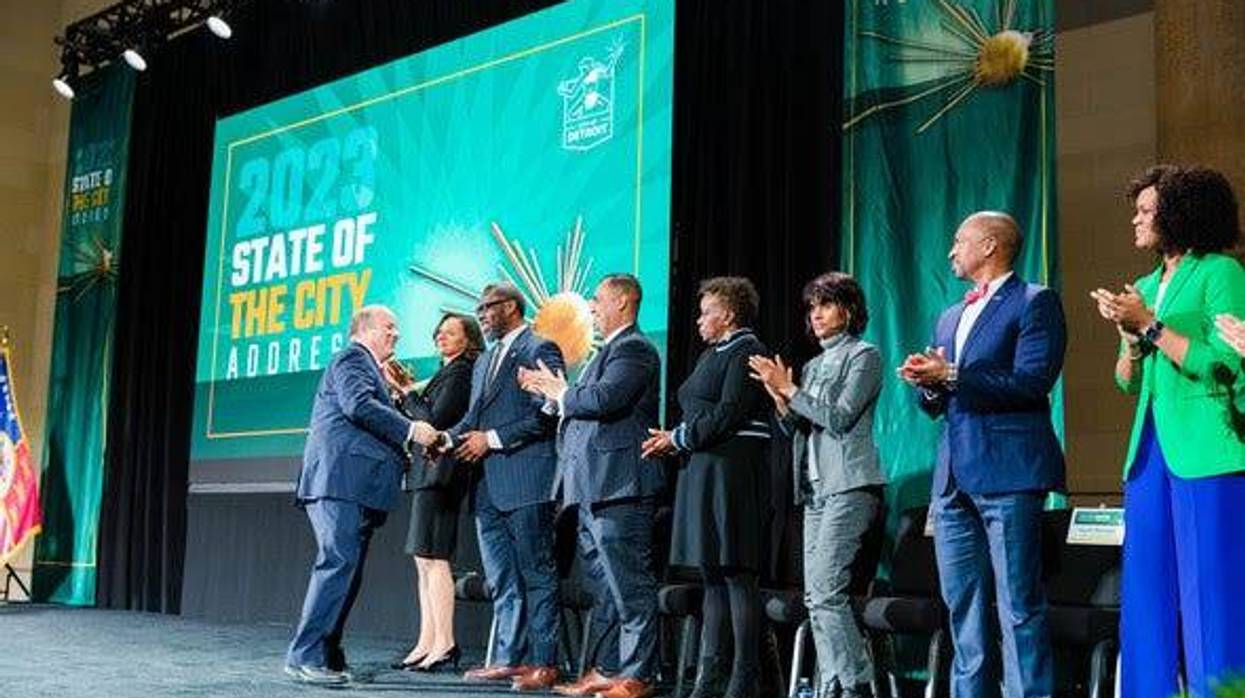 Detroit Mayor Mike Duggan shakes hands on stage at the State of the City address