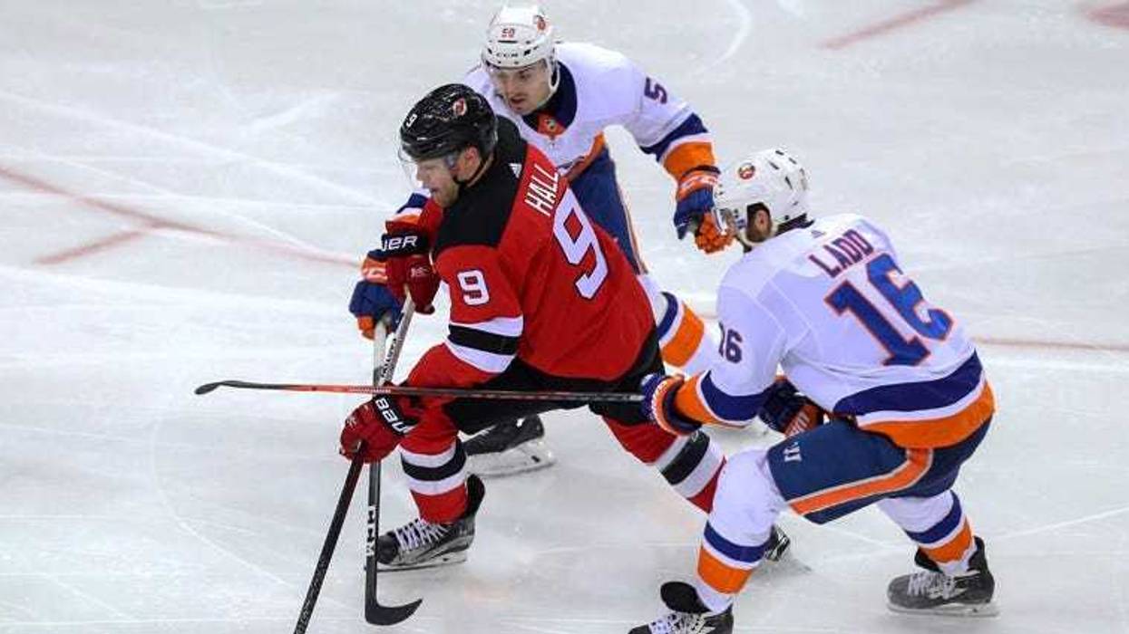 Devils left wing Taylor Hall skates with the puck between Islanders left wing Andrew Ladd (16) and defenseman Adam Pelech on March 31, 2018, at Prudential Center.