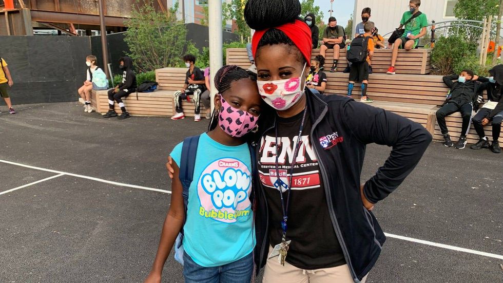 Dior, 11, and her mother Latora Brown wait for the day to start on the first day of the school year at Science Leadership Academy Middle School in University City, Philadelphia.