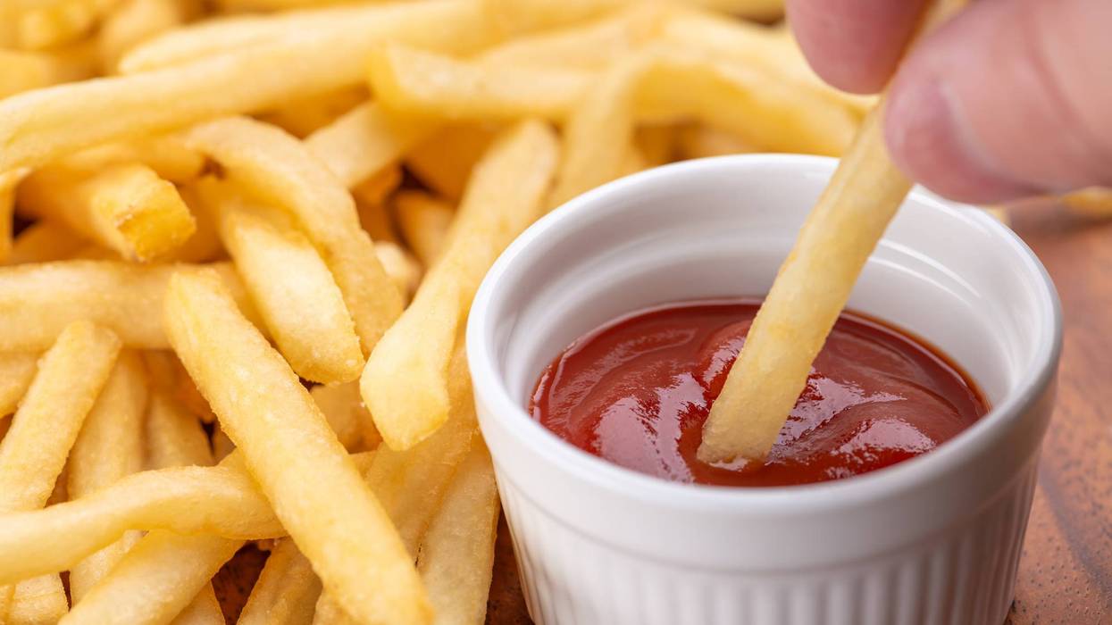 Dipping Fried Potatoes in Ketchup and Eating