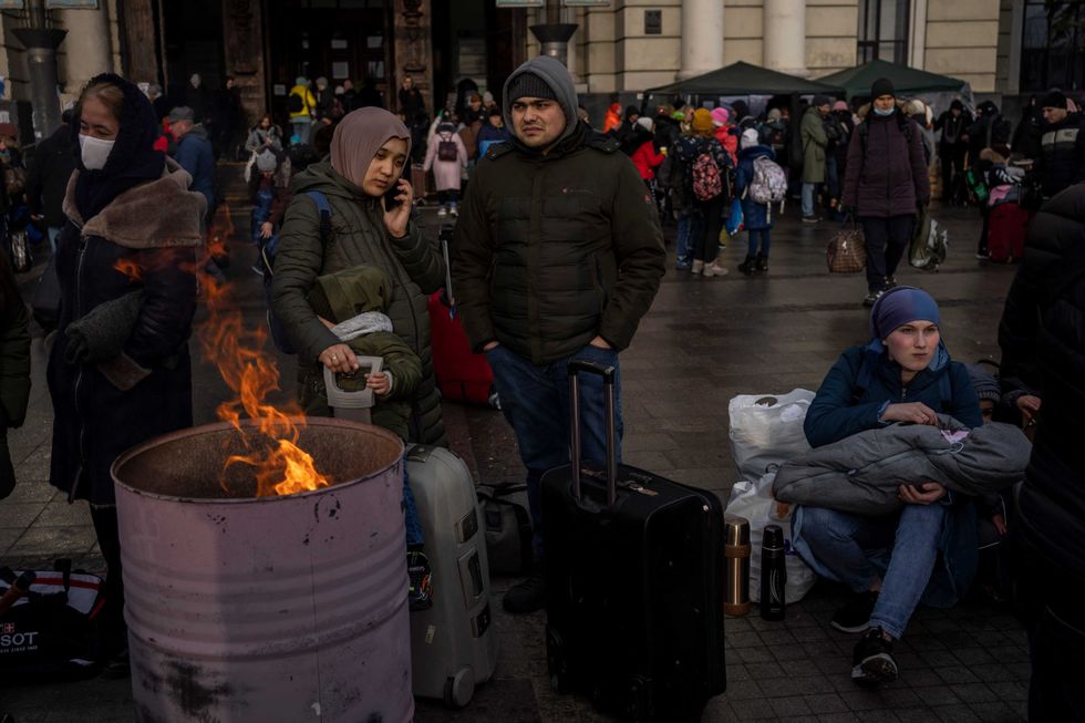 Displaced people gather around a bonfire outside Lviv railway station, in Lviv, western Ukraine, Thursday, March 3, 2022