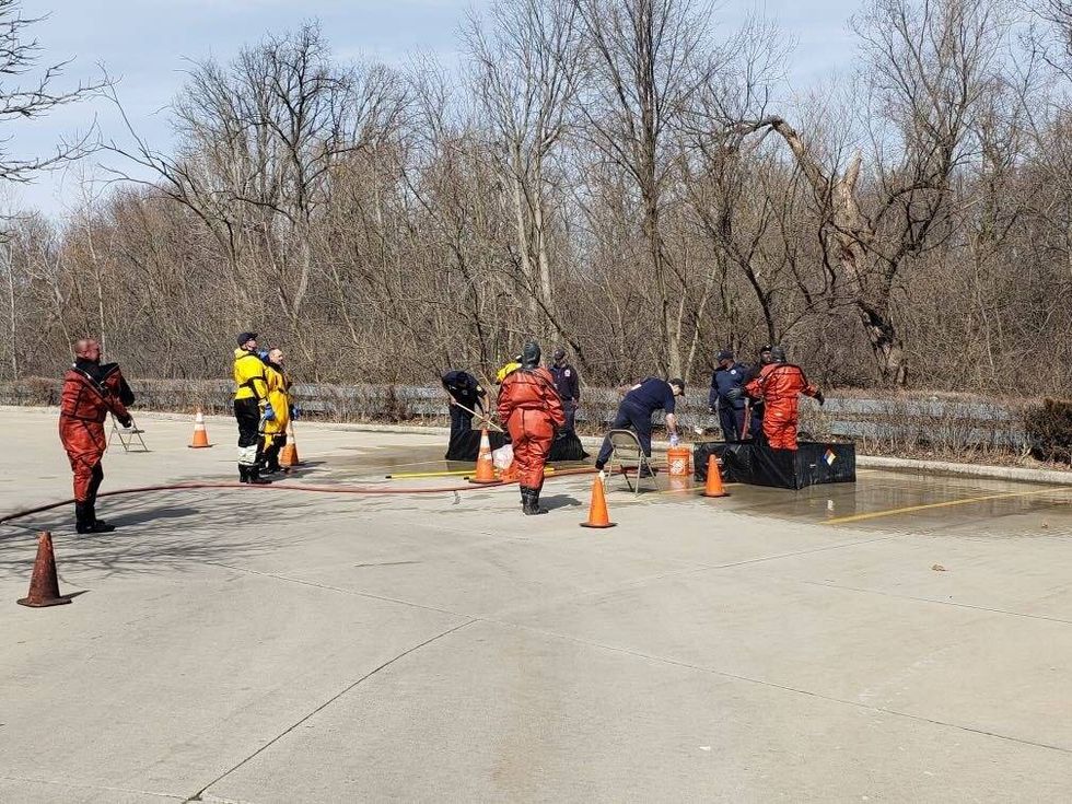Divers are seen at the makeshift command center in the parking lot of Greater Grace Temple, which borders the Rouge River.