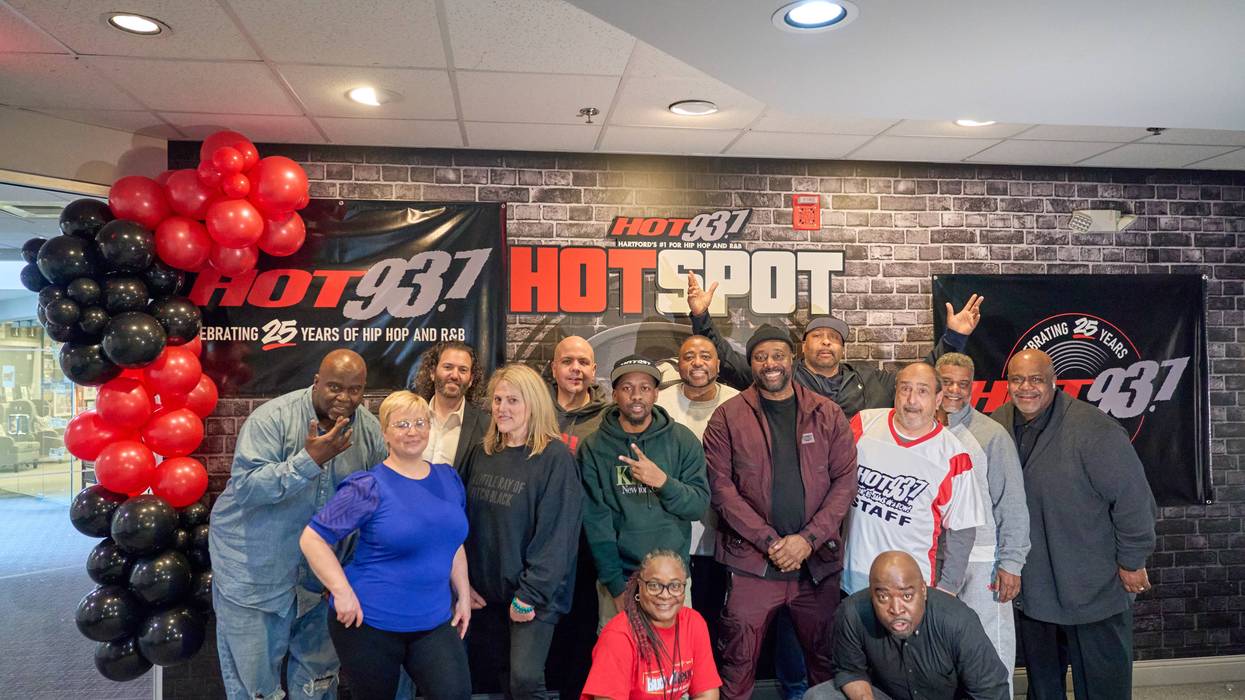 Diverse Hot 93.7 team celebrates 25 years of Hip Hop and R&B with red and black balloons.