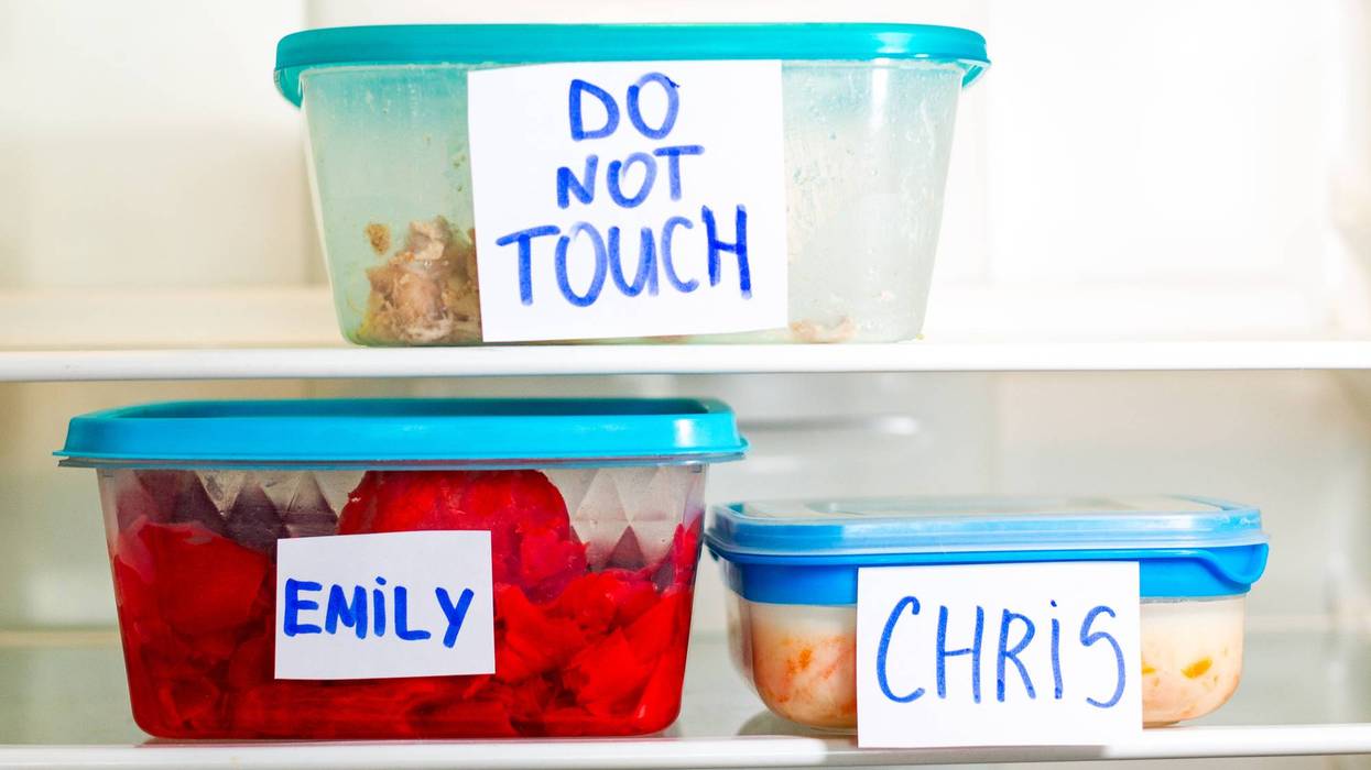 Do Not Touch sticker on lunch boxes in office refrigerator. Angry and hungry workers concept.
