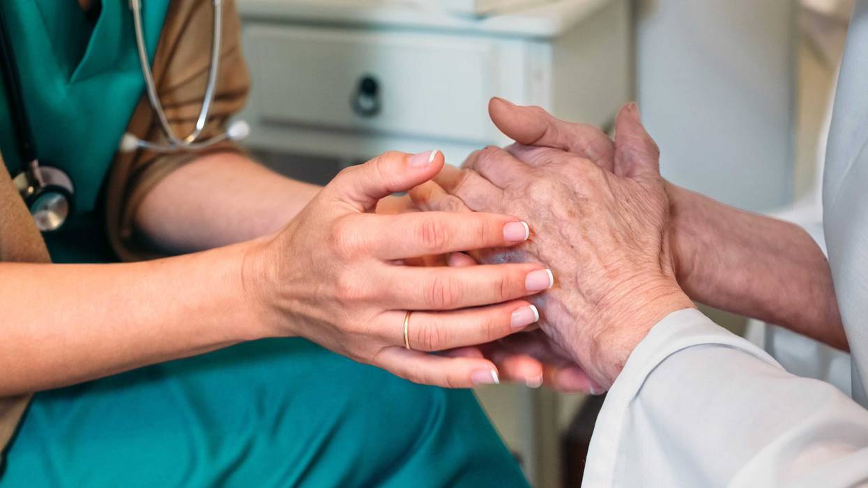 Doctor giving encouragement to elderly patient - stock photo