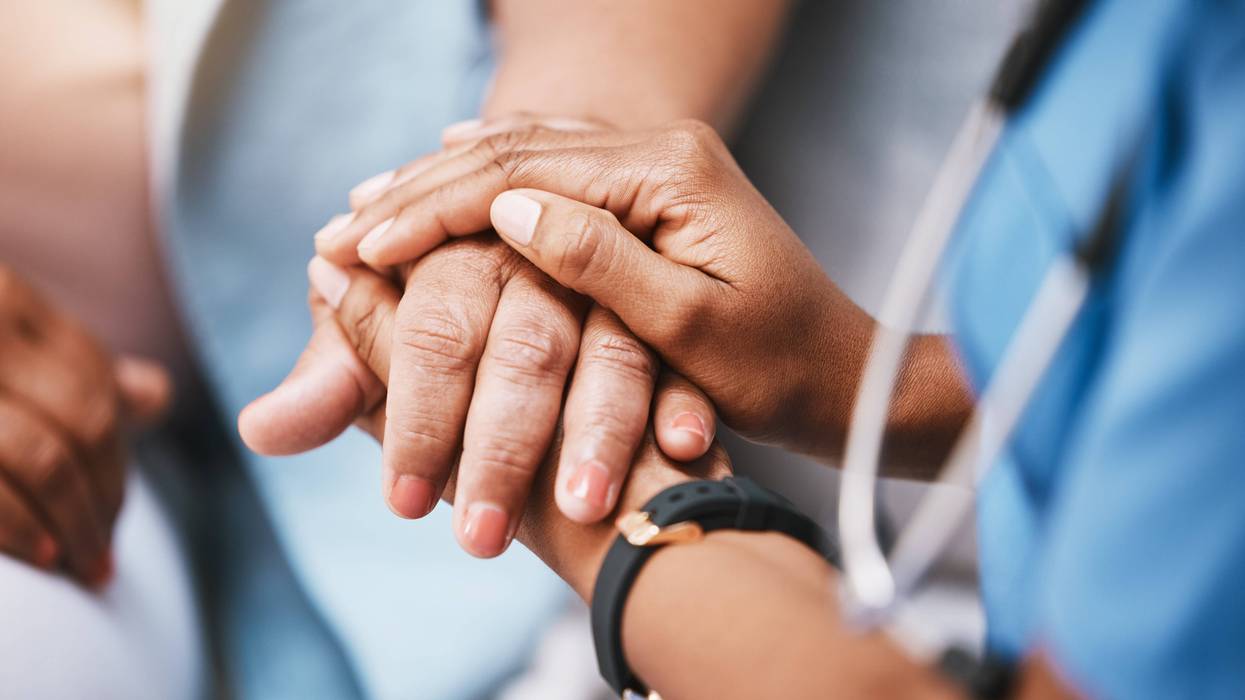 doctor holds patient's hand