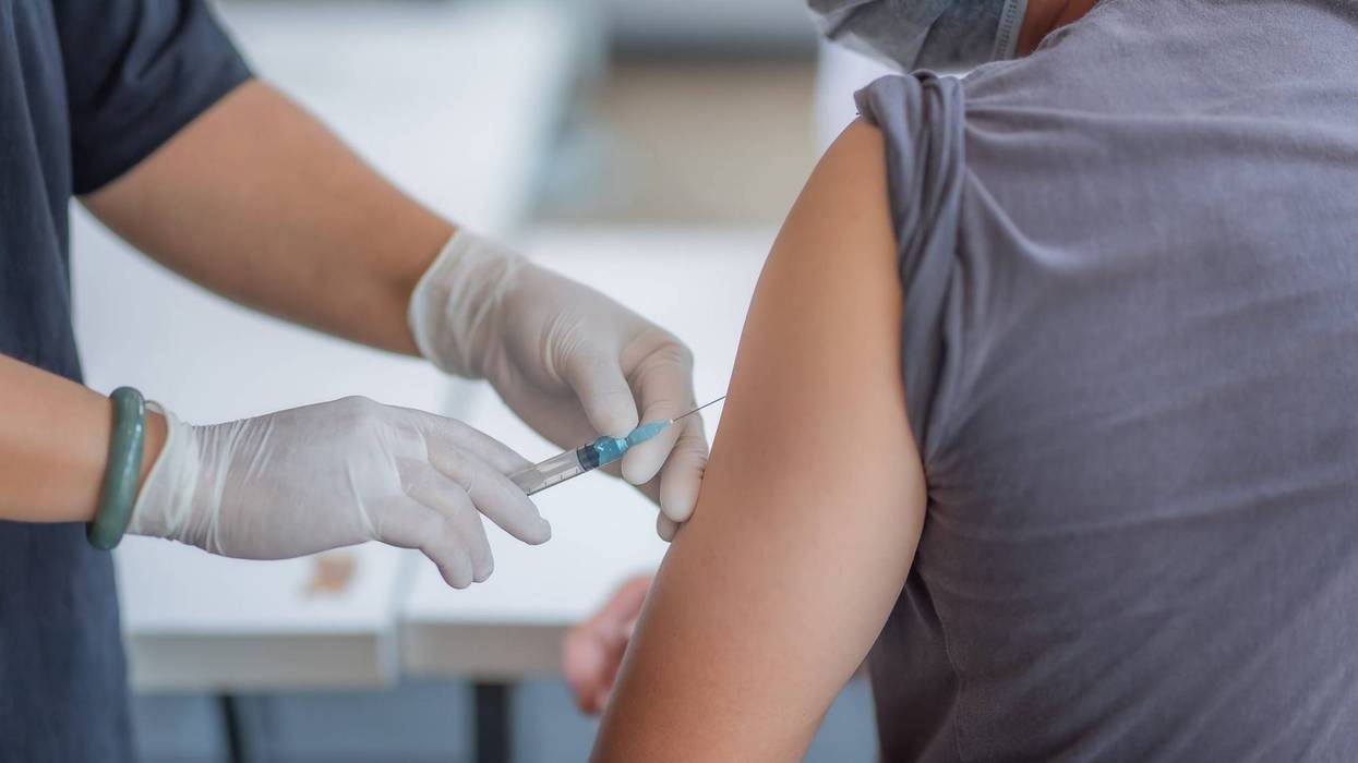 doctor injects male patient with vaccine