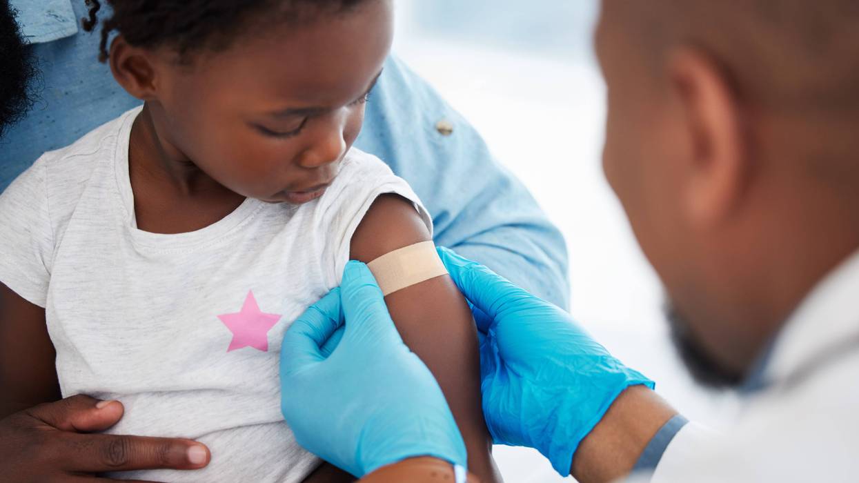 Doctor puts bandage on child after giving vaccine