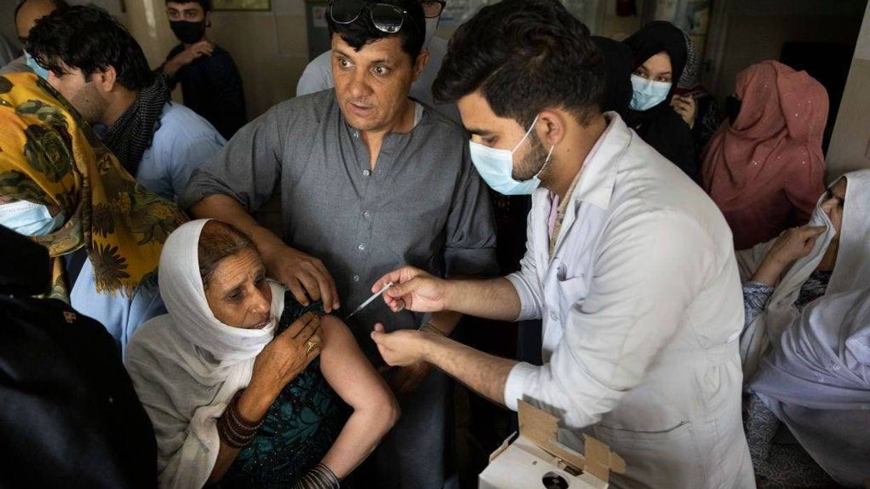 Doctor Roheed Mureed (right) vaccinates Afghans with the J&J vaccine at the Wazir Akbar Khan hospital on July 14, 2021 in Kabul, Afghanistan. More than 1.4 million doses of the Johnson & Johnson COVID-19 vaccine arrived in Afghanistan (where vaccination rates were 2 percent and lower as of Aug. 5) that were donated by the United States to COVAX, the total donation is around 3.3 million doses. (Photo by Paula Bronstein/Getty Images).