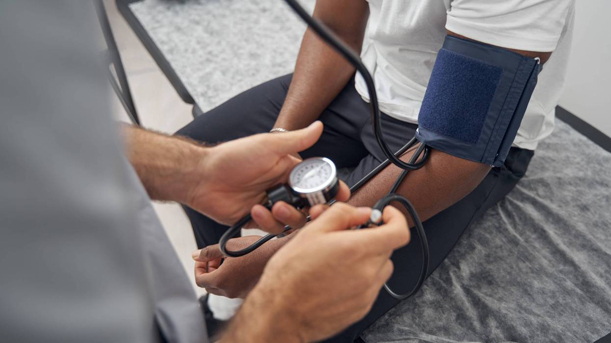 Doctor taking an African American patient's blood pressure.