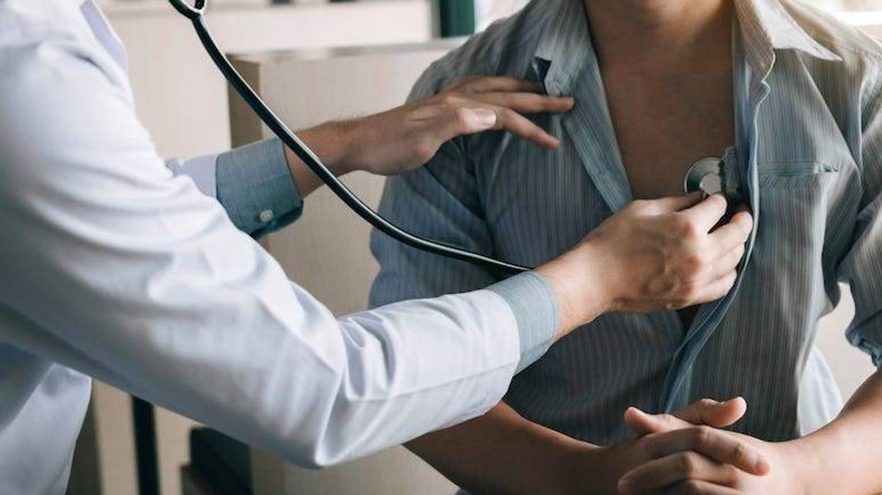 Doctor using stethoscope on patient
