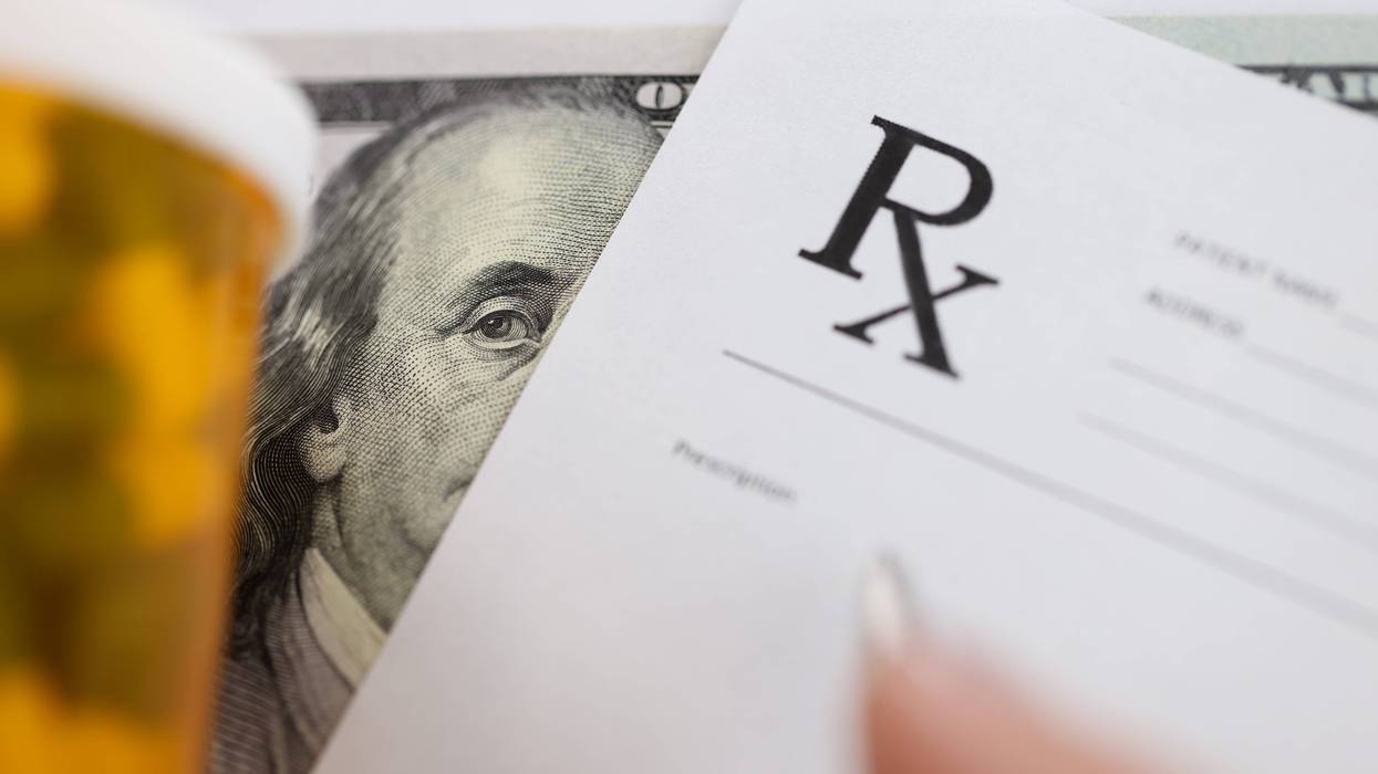 Dollar bill and doctors prescription are on doctors table in clinic closeup.