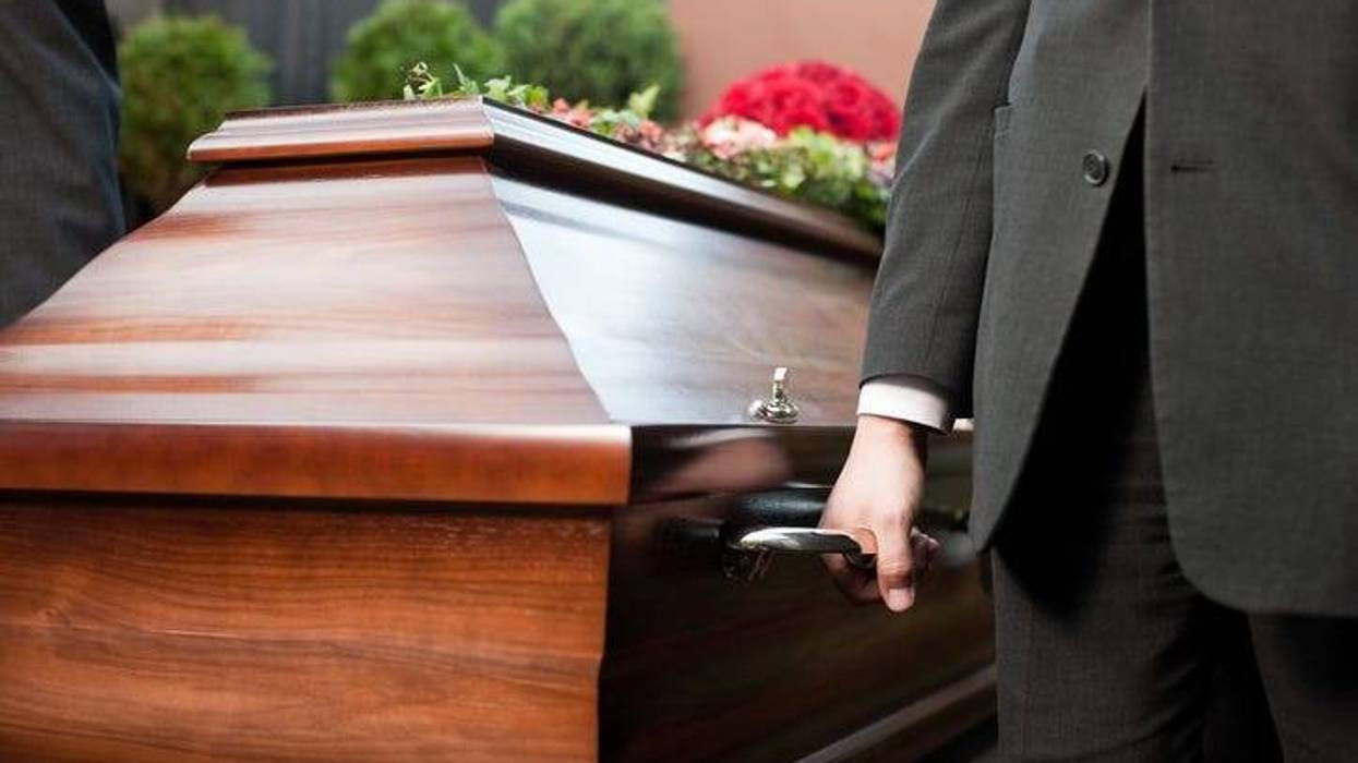 Dolor - Funeral with coffin on a cemetery, the casket carried by coffin bearer