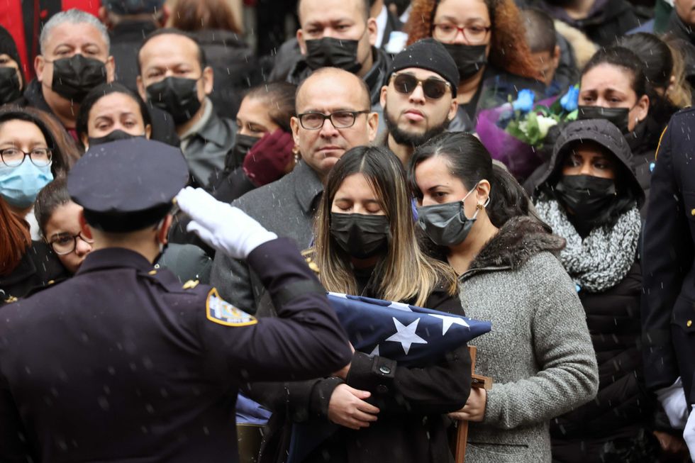 Dominique Rivera, the wife of fallen NYPD Officer Jason Rivera, holds a flag from his casket during his funeral at St. Patrick