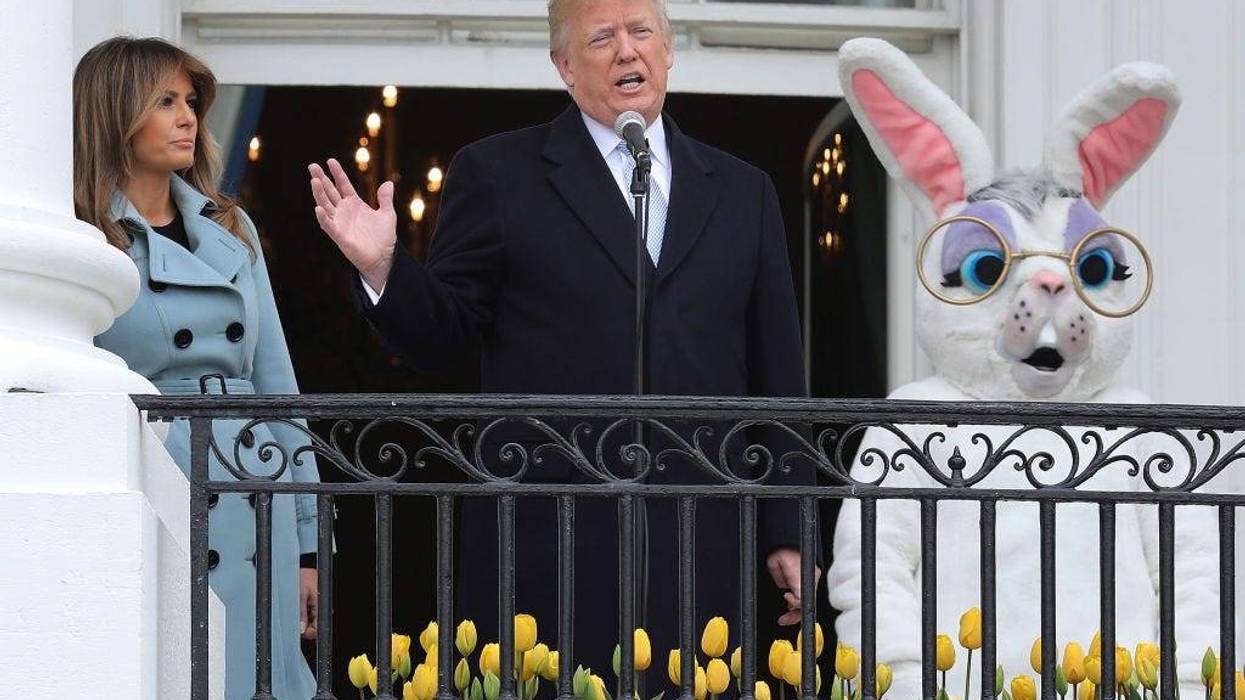 Donald Trump (C) and first lady Melania Trump (L) walk out onto the Truman Balcony with a person in an Easter Bunny costume during the 140th annual Easter Egg Roll on the South Lawn of the White House April 2, 2018 in Washington, DC.