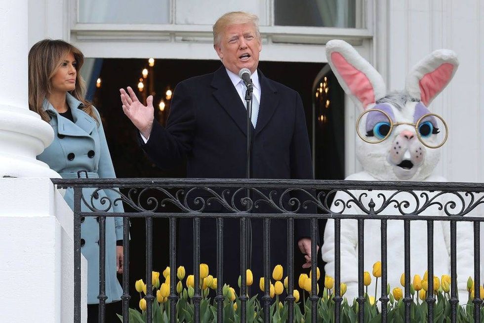 Donald Trump (C) and first lady Melania Trump (L) walk out onto the Truman Balcony with a person in an Easter Bunny costume during the 140th annual Easter Egg Roll on the South Lawn of the White House April 2, 2018 in Washington, DC.