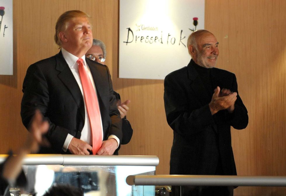 Donald Trump (L) and Sir Sean Connery look on as models walk the runway at the 8th annual "Dressed To Kilt" Charity Fashion Show presented by Glenfiddich at M2 Ultra Lounge on April 5, 2010 in New York City.