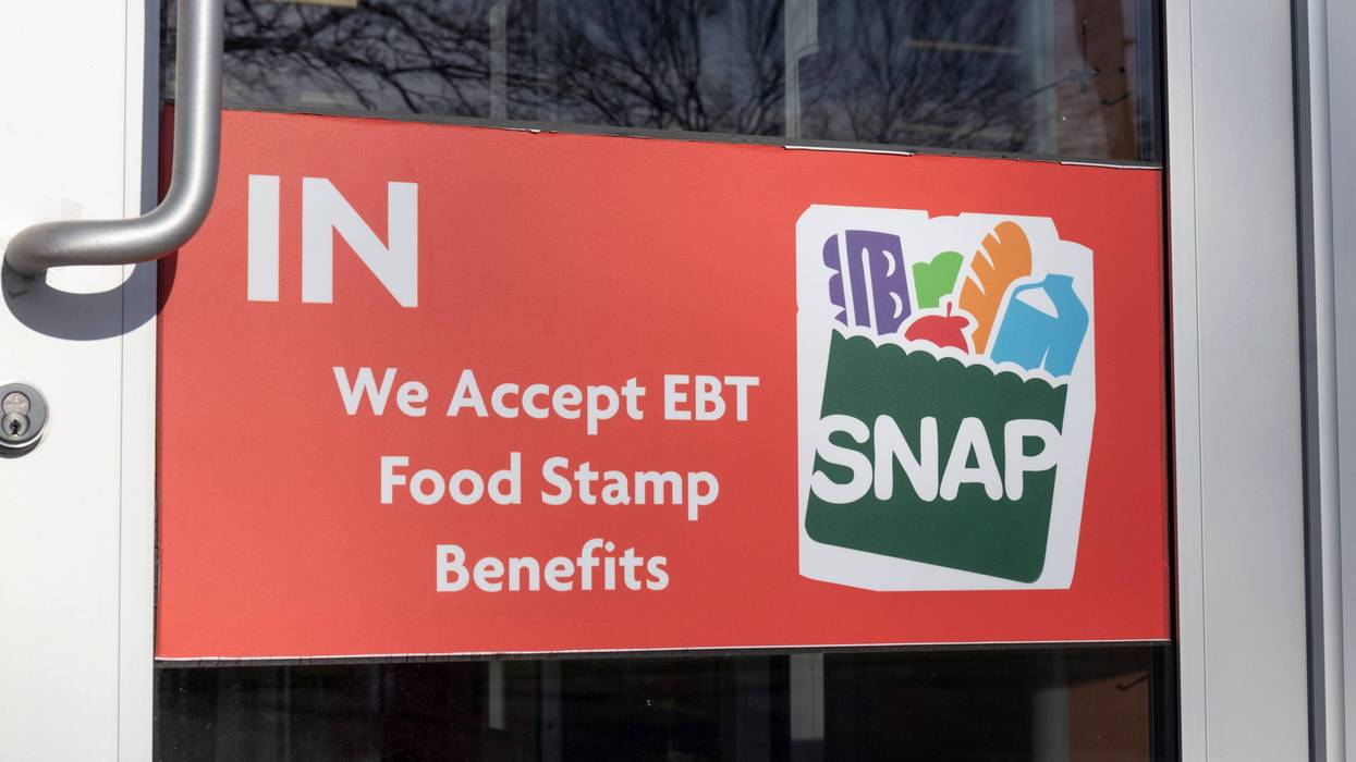 door with signage saying "IN. We accept EBT Food Stamp Benefits"