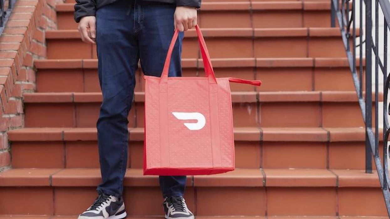 DoorDash driver holding a delivery bag