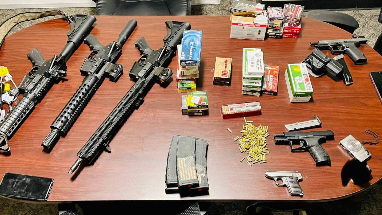 Downriver police officers stumbled across two suspects and a cache of stolen firearms and ammunition after responding to shots fired, authorities said on Wednesday.