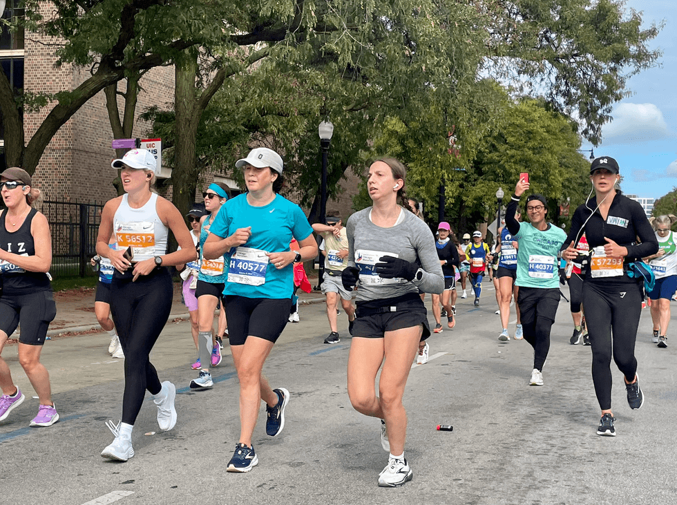 Dozens of runners race along a Chicago street during the Chicago Marathon.