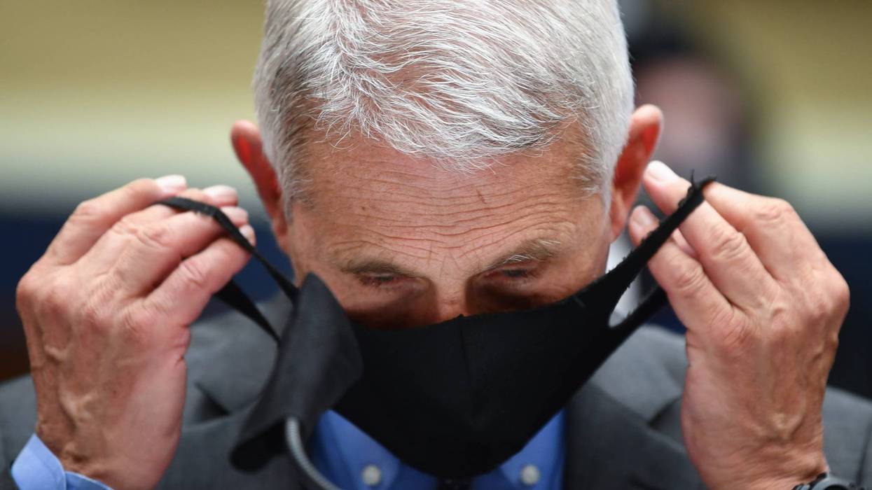 Dr. Anthony Fauci, director of the National Institute of Allergy and Infectious Diseases, takes off his face mask before testifying at a hearing of the U.S. House Committee on Energy and Commerce on Capitol Hill on June 23, 2020 in Washington, DC.