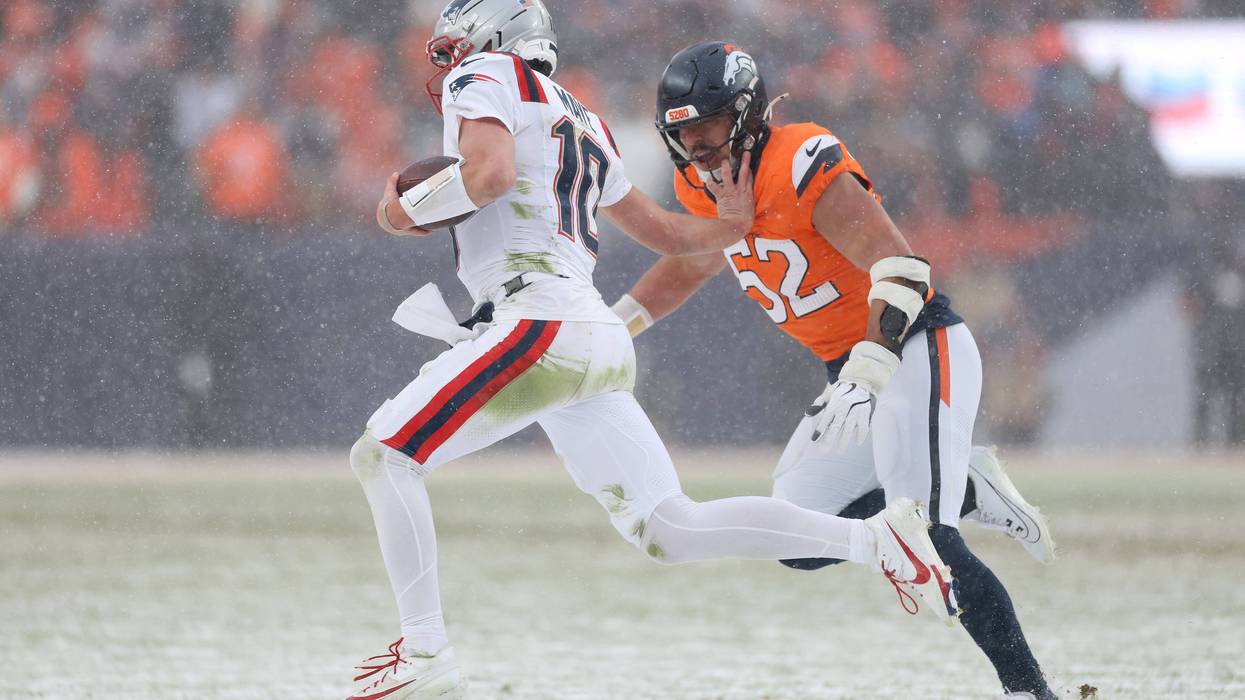Drake Maye #10 of the New England Patriots stiff arms Jonah Elliss #52 of the Denver Broncos during the fourth quarter in the AFC Championship Playoff game at Empower Field At Mile High on January 25, 2026 in Denver, Colorado.