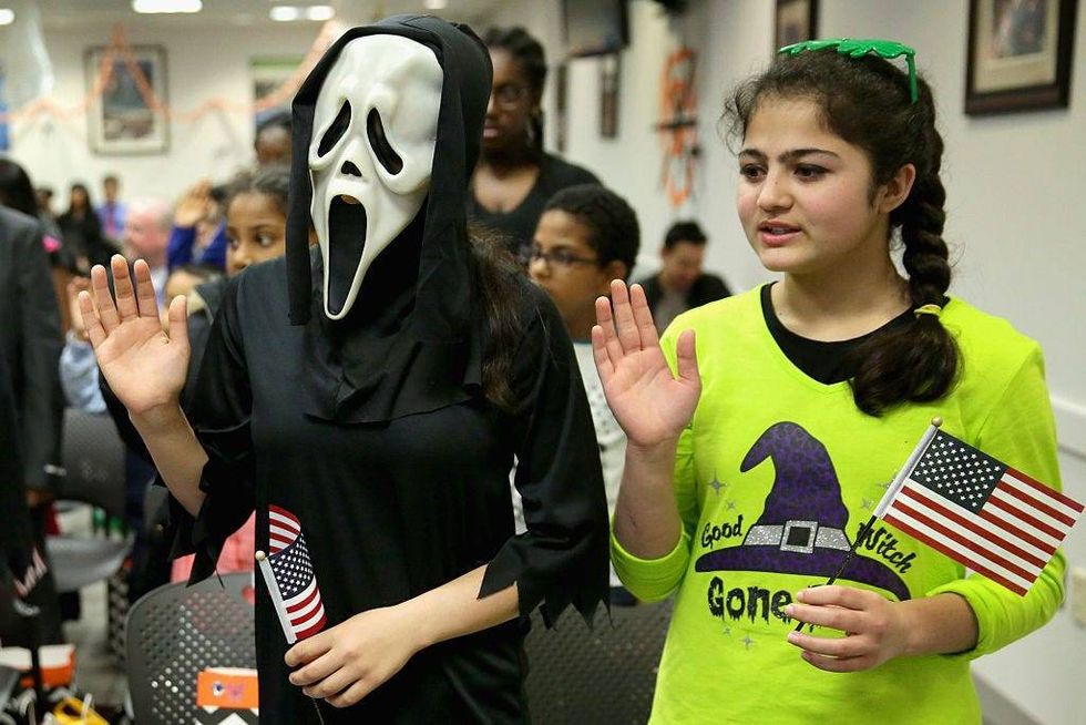 Dressed as the title character from the movie Scream, Javaria Khattak (L), 14, her sister Mishal Khattak, 12, and 26 other children wear Halloween costumes.