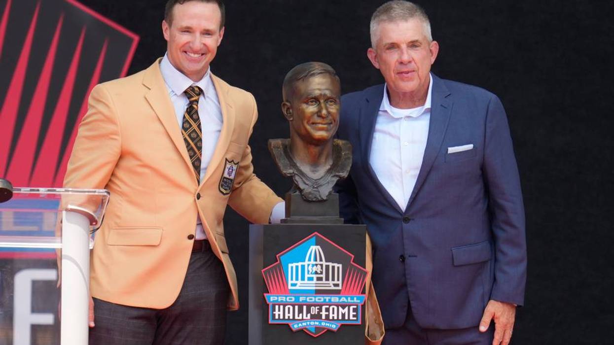 Drew Brees and Sean Payton next to Brees' bronze bust at the Pro Football Hall of Fame.