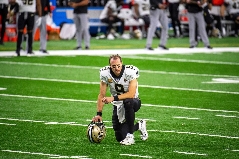 Drew Brees take a knee during the Saints