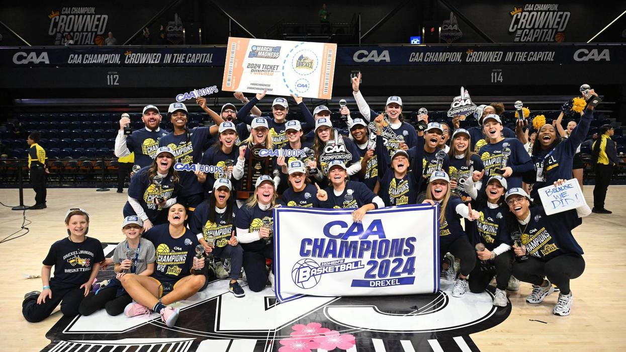 Drexel University's women's basketball team on the court holding a "CAA Champions" banner.