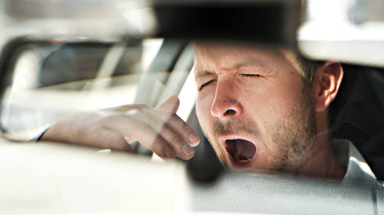 driver yawning, seen in mirror