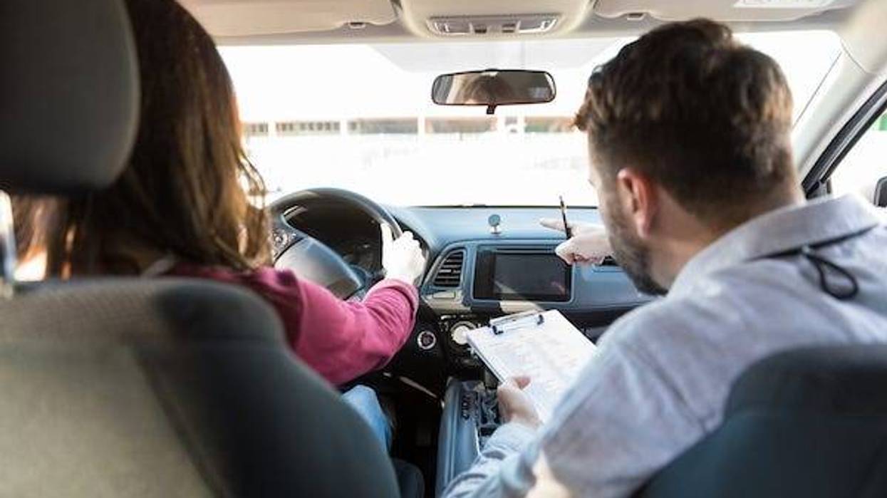 Driving instructor guiding student in a car
