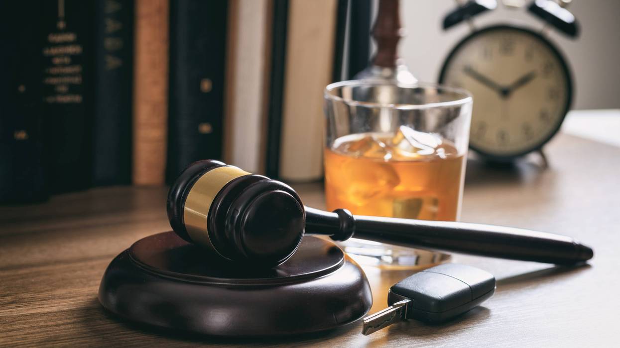 DUI concept. Law gavel, alcohol and car keys on a wooden desk, dark background