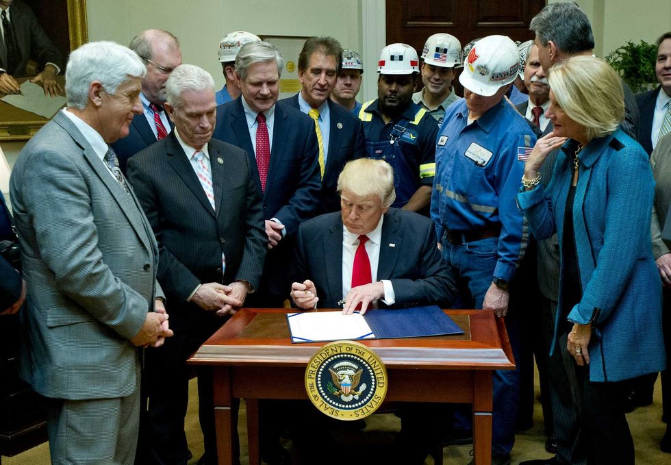 During his first term in office, U.S. President Donald Trump signs H.J. Res. 38, disapproving the rule submitted by the US Department of the Interior known as the Stream Protection Rule in the Roosevelt Room of the White House on February 16, 2017 in Washington, DC. The Department of Interior