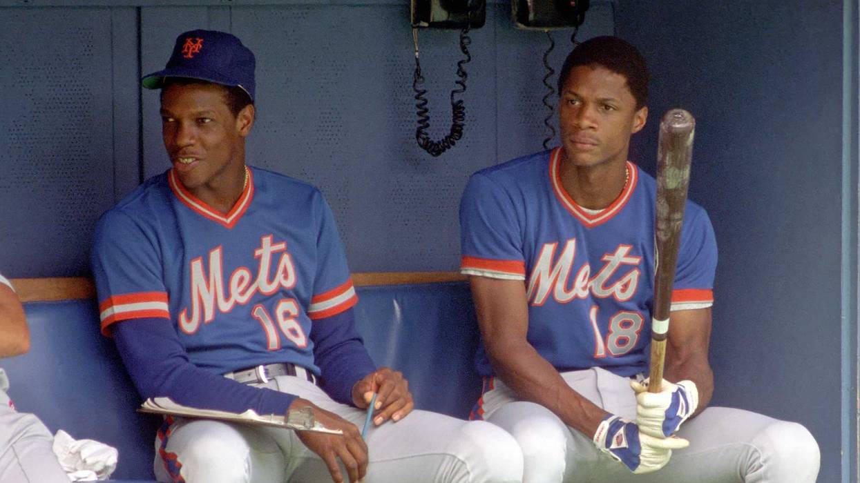 Dwight Gooden #16 and Darryl Strawberry #18 of the New York Mets look on from the dugout during a Major League Baseball game against the Pittsburgh Pirates at Three Rivers Stadium in 1984 in Pittsburgh, Pennsylvania.