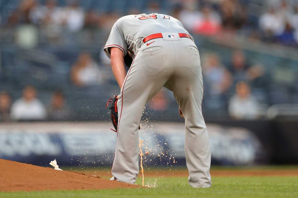 Dylan Bundy #37 of the Los Angeles Angels falls ill while pitching during the second inning against the New York Yankees at Yankee Stadium on June 28, 2021.