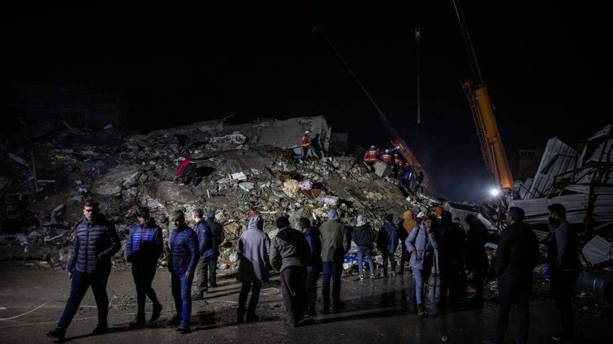 Earthquake survivors spend the night as they wait near the collapsed buildings on February 06, 2023 in Iskenderun Turkey.