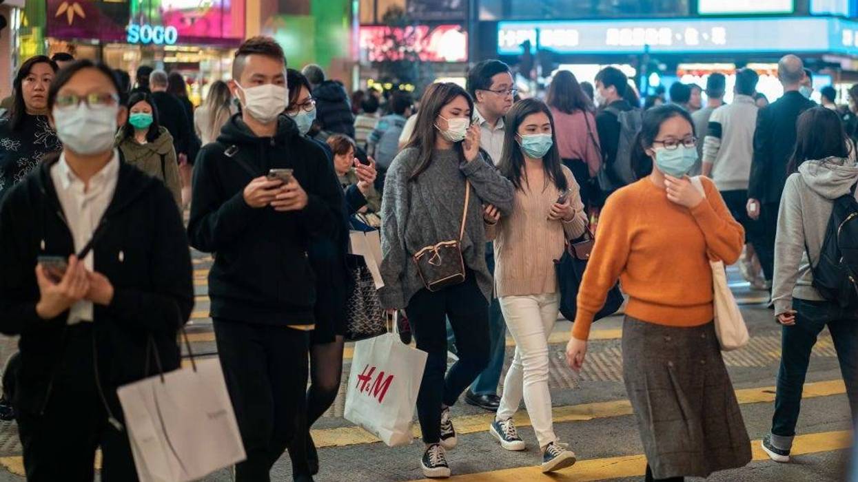 edestrians wear face masks as they walk through a crosswalk in Causeway Bay district on January 23, 2020 in Hong Kong, China.