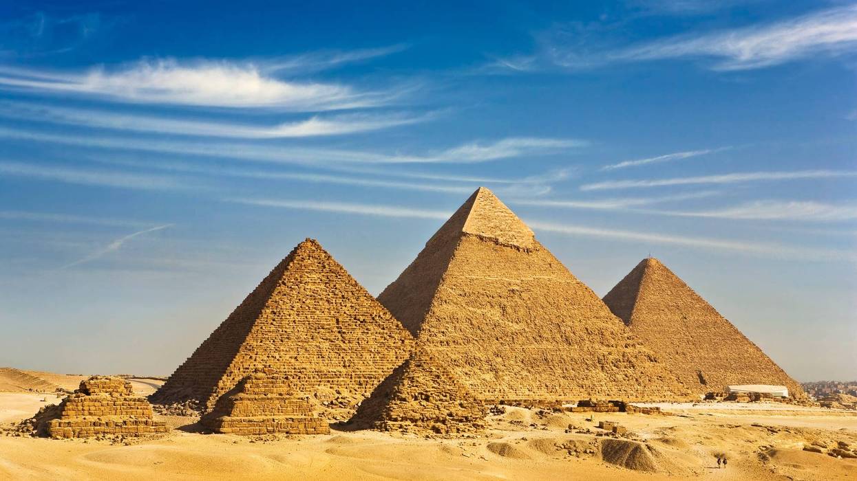"Egypt. Cairo - Giza. General view of pyramids from the Giza Plateau (there is three pyramids popularly known as Queens' Pyramids on front side; next in order from left: the Pyramid of Menkaure /Mykerinos/, Khafre /Chephren/ and Chufu /Cheops/ - known as the Great Pyramid). The Pyramid Fields from Giza to Dahshur is on UNESCO World Heritage List"