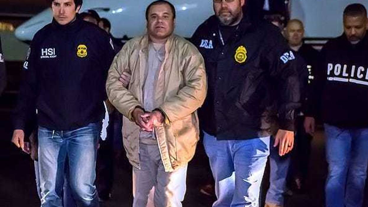 El Chapo is escorted by DEA agents.