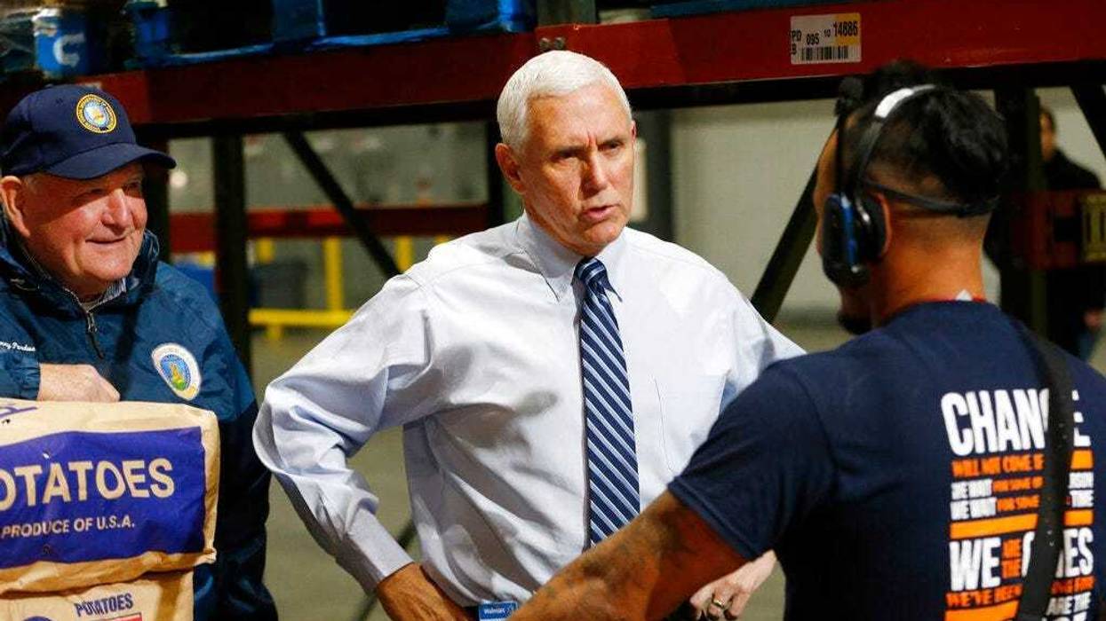 El vicepresidente de EEUU, Mike Pence, acompañado por el secretario de Agricultura, Sonny Perdue, durante un recorrido en un centro de distribución de Walmart, en Gordonsville, Virginia, el 1 de abril de 2020. (AP Foto/Steve Helber)