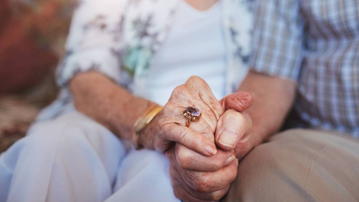 elderly couple holding hands
