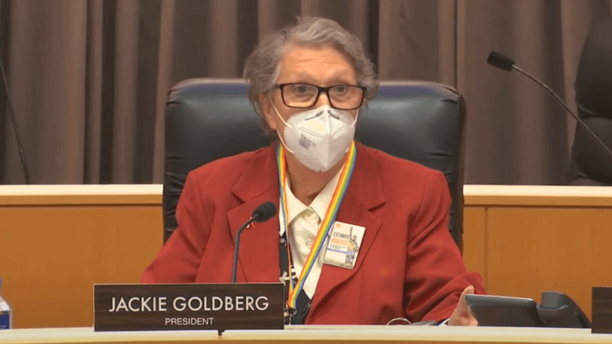 elderly woman wearing mask in school board meeting room