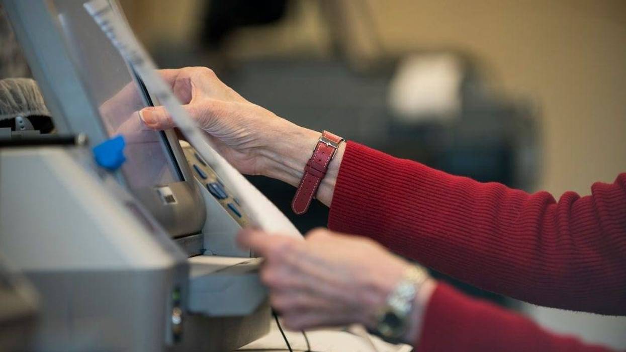 Election official Mary Wickersham enters selections into a voting machine during a public accuracy testing of Election Day voting machines, Oct. 23, 2018 in Minnesota.