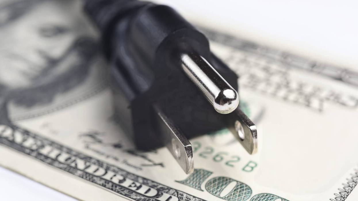 Electric plug on top of $100 bill