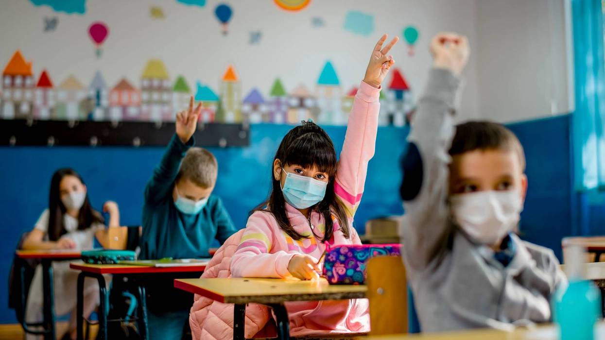 Elementary schoolchildren wearing a protective face masks in the classroom
