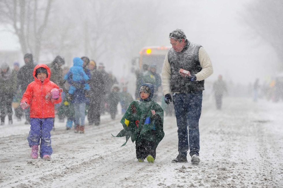 Ella, Cooper, and Colin Reilly march through lake effect snow during the annual Hamburg Holiday Parade on November 30, 2024 in Hamburg, New York