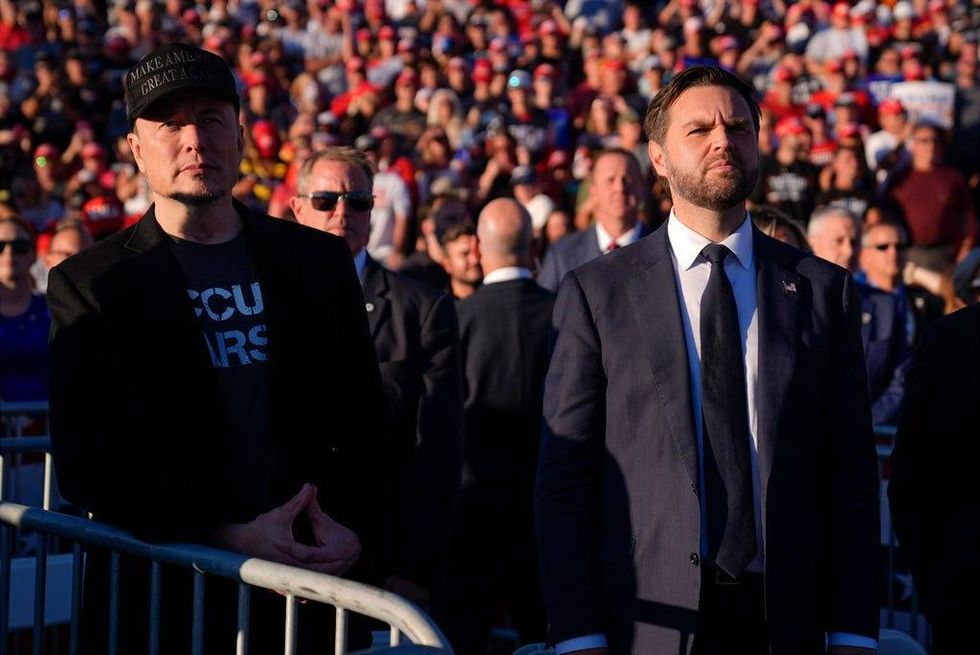 Elon Musk and Republican vice presidential nominee Sen. JD Vance listen as Republican presidential nominee former President Donald Trump speaks at a campaign rally at the Butler Farm Show, Saturday, Oct. 5, 2024, in Butler, Pa.